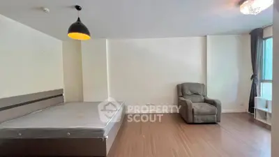 Spacious bedroom with modern lighting and large window for natural light.