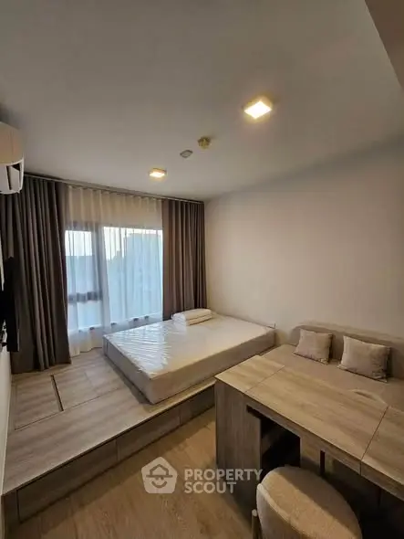 Modern minimalist bedroom with platform bed and cozy seating area, perfect for urban living.