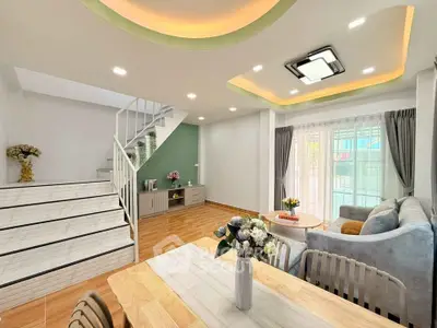 Modern living room with stylish decor and staircase in a bright, open space