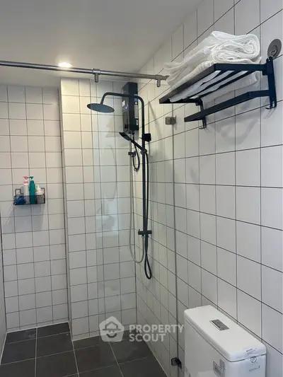 Modern bathroom with sleek shower and towel rack in tiled interior