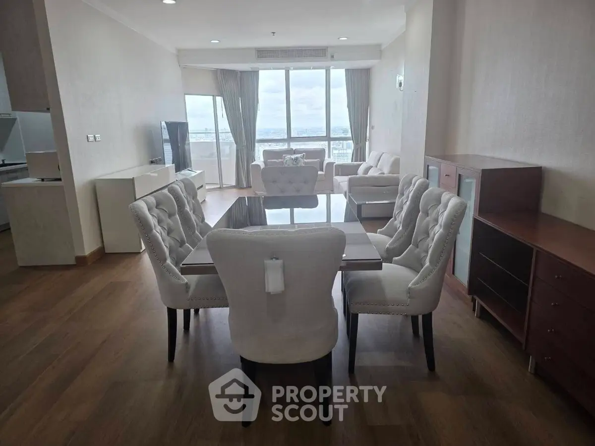 Spacious modern living room with elegant dining area and stunning city view.