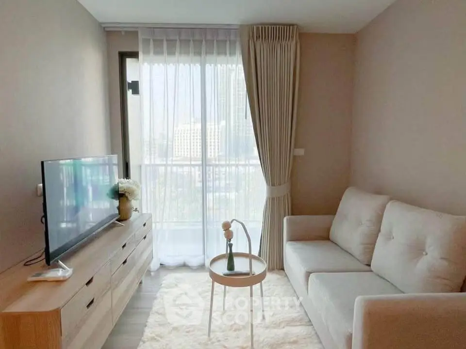 Cozy living room with modern decor, plush sofa, and large window offering city views.