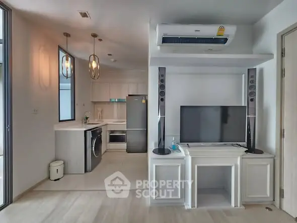 Modern open-plan living room with sleek kitchen and stylish appliances