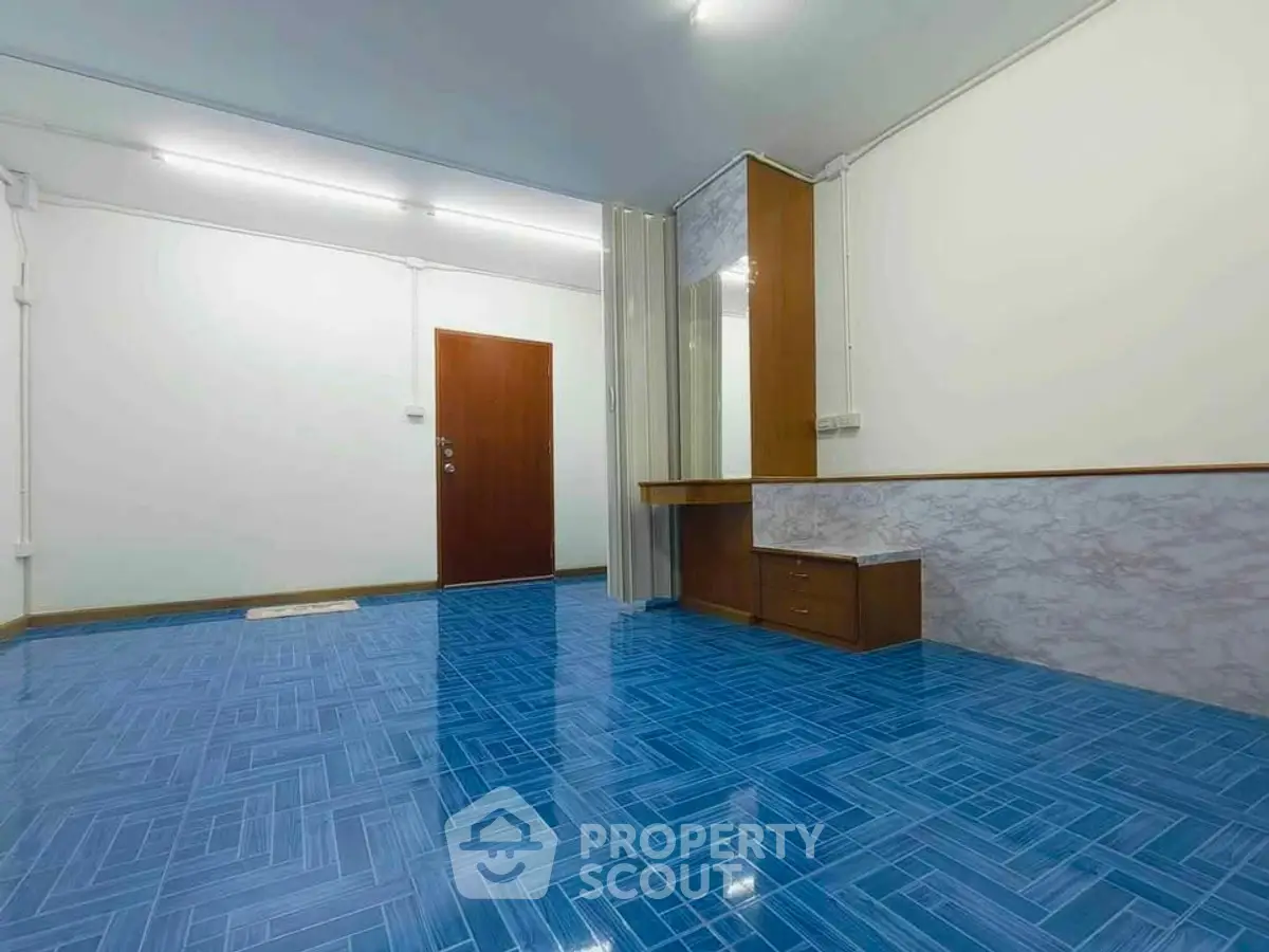 Spacious room with vibrant blue flooring and modern wooden accents