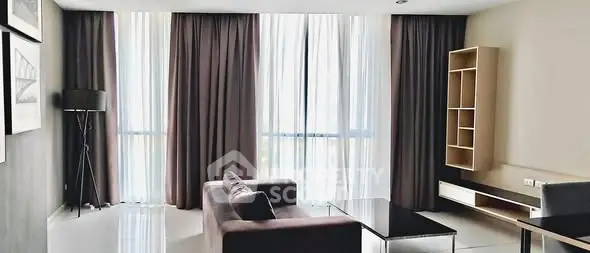 Spacious modern living room with large windows and elegant furnishings.