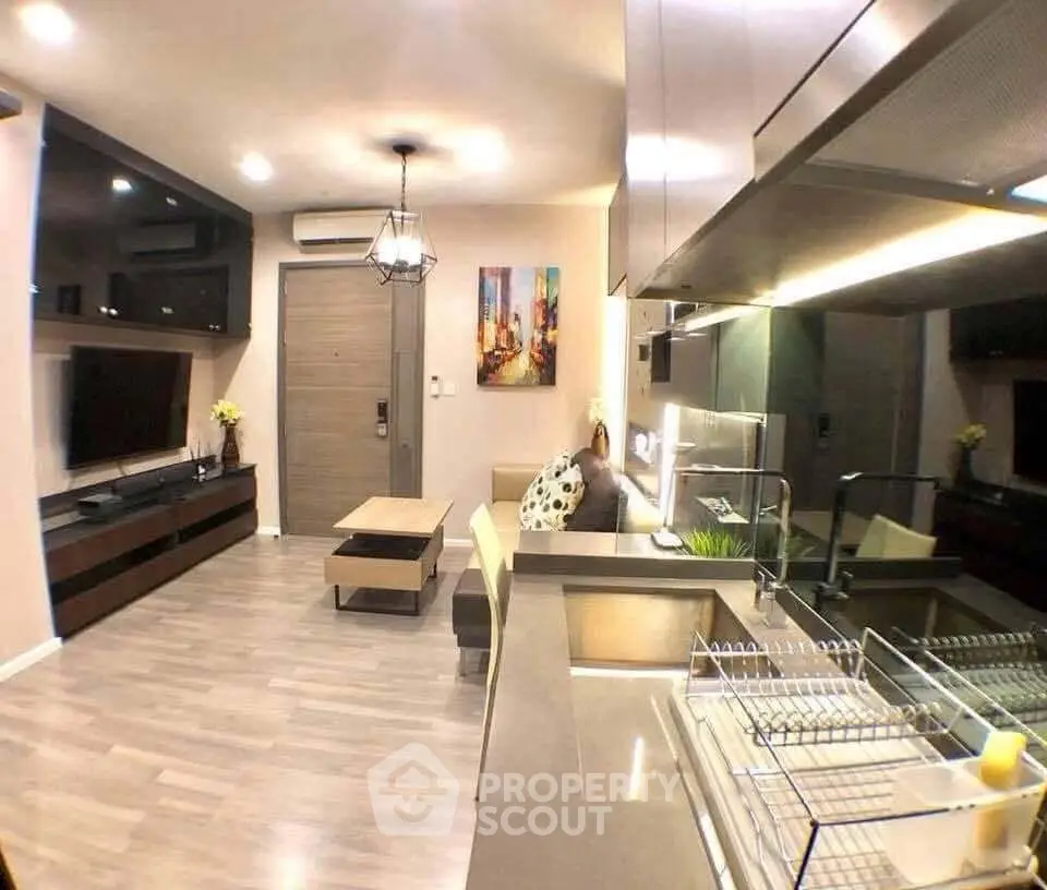 Modern open-layout living room and kitchen with sleek design and stylish decor.