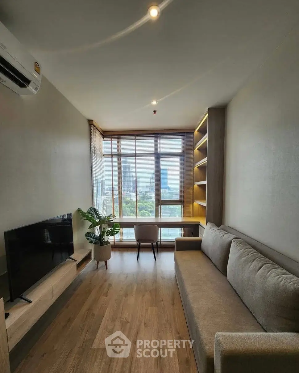 Modern living room with large window and city view, featuring a cozy sofa and stylish decor.