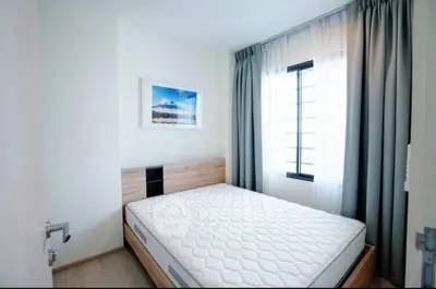 Bright and airy bedroom with modern decor and large window for natural light.