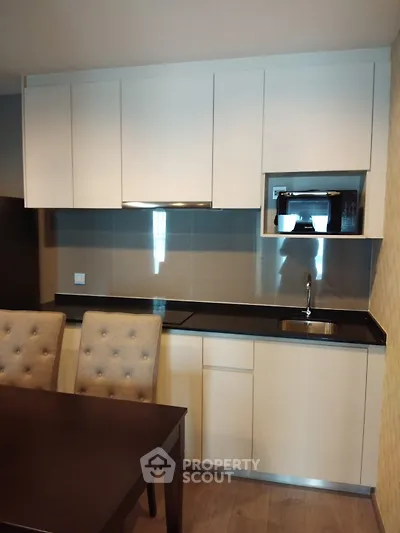 Modern kitchen with sleek cabinetry and built-in appliances in a stylish apartment.