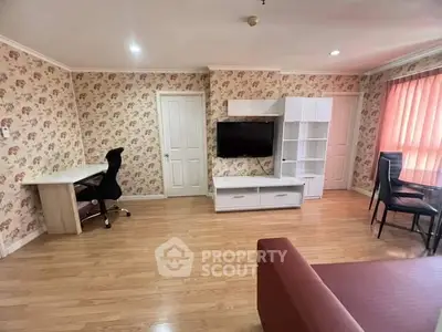 Spacious living room with modern furniture and floral wallpaper, ideal for comfortable living.