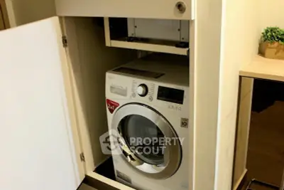 Modern apartment with built-in washing machine in sleek cabinet design.