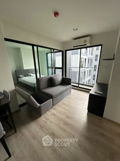 Modern apartment with open layout, featuring a cozy living room and bedroom with balcony view.
