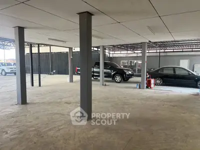 Spacious parking area with multiple vehicles and sturdy pillars, ideal for commercial use.