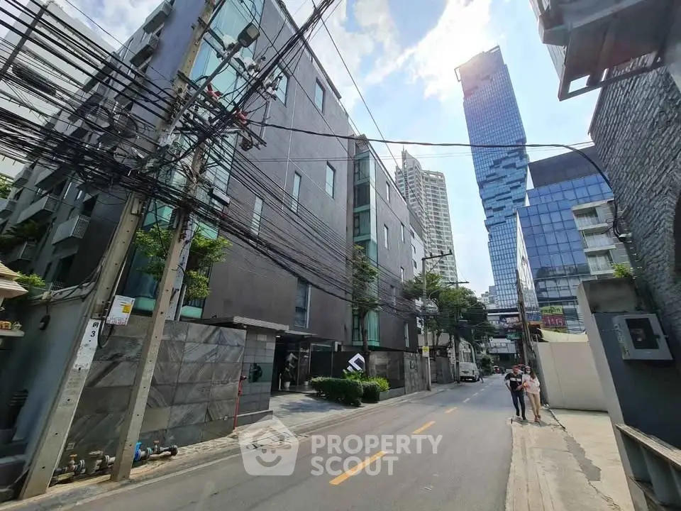 Modern urban street view with contemporary buildings and clear blue sky.