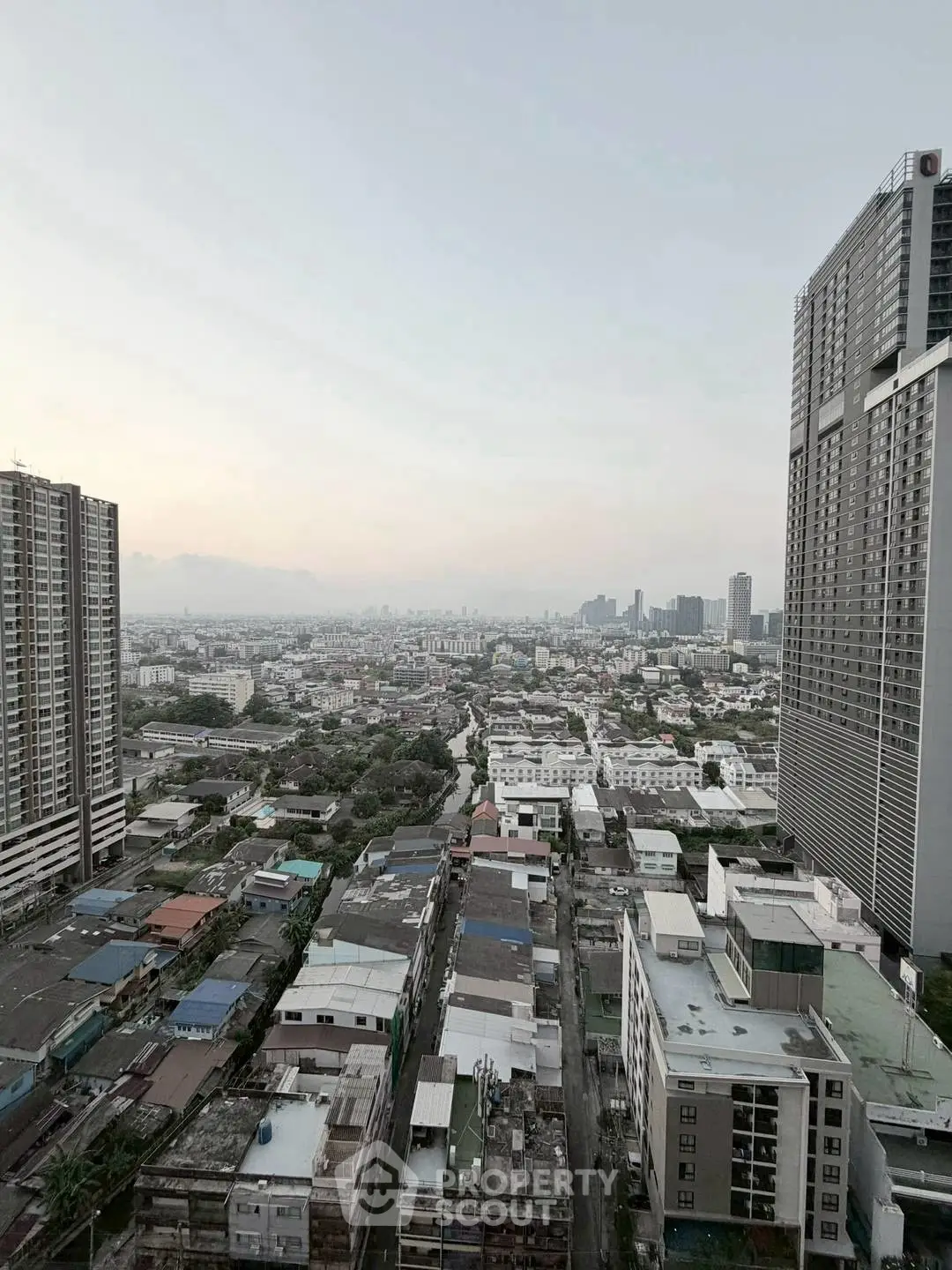 Stunning cityscape view from high-rise building showcasing urban skyline and residential areas.
