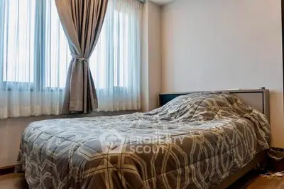 Cozy bedroom with large windows and elegant curtains in modern apartment.
