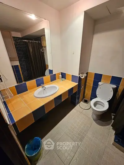 Spacious bathroom with modern fixtures and colorful tile accents, perfect for a stylish home.
