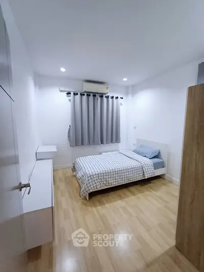 Cozy minimalist bedroom with wooden flooring and modern decor