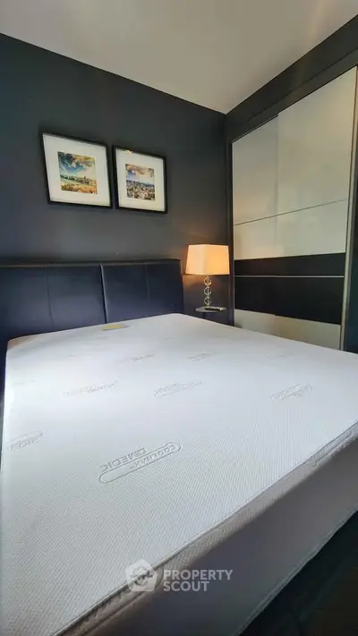 Modern bedroom with stylish decor and comfortable mattress in a sleek apartment.