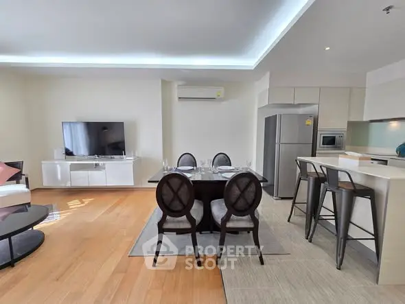 Modern open-plan living and dining area with sleek kitchen and stylish furniture.