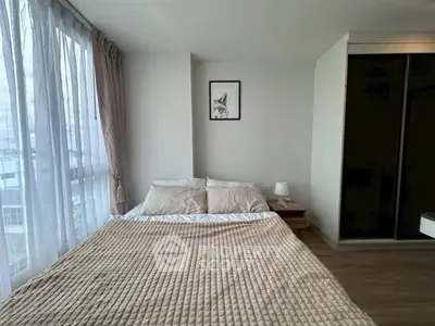 Cozy bedroom with large window and modern decor in a stylish apartment.