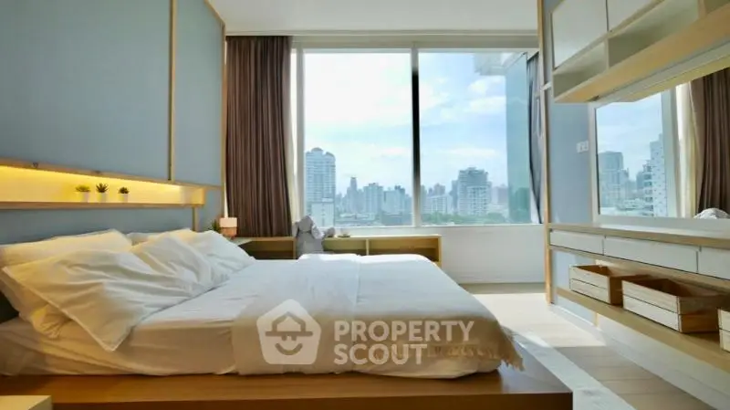 Luxurious bedroom with stunning city view and modern decor in high-rise apartment.