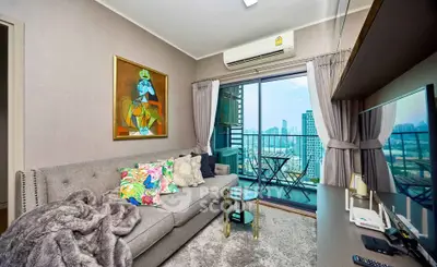Stylish living room with balcony and city view, featuring modern decor and cozy seating.
