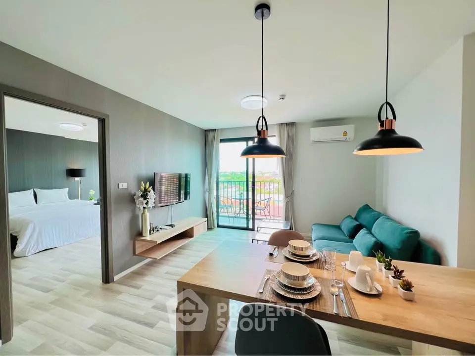 Modern open-plan living room with dining area and balcony view in a stylish apartment.