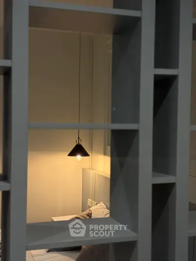 Cozy bedroom with modern lighting and stylish shelving for a serene ambiance.