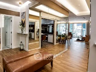 Luxurious modern living room with mirrored walls and city view, featuring elegant decor and wooden flooring.