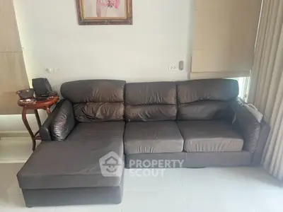 Spacious living room with elegant leather sectional sofa and natural light