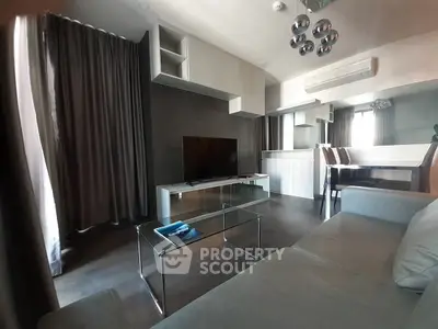 Modern living room with sleek furniture and large TV, perfect for relaxation.