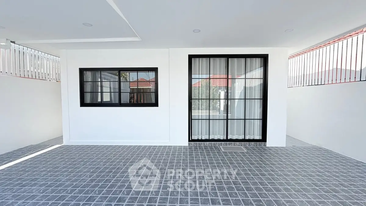 Modern minimalist exterior with sleek windows and tiled flooring, perfect for contemporary living.