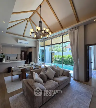 Luxurious open-plan living room with high ceilings and pool view, perfect for modern living.
