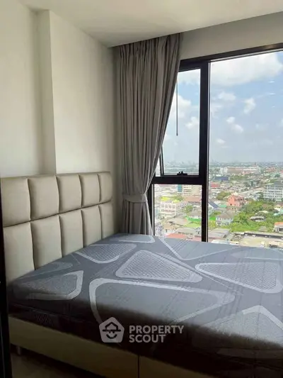 Cozy bedroom with city view, featuring a modern bed and large window with curtains.
