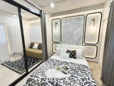 Luxurious modern bedroom with elegant decor and glass partition to cozy living area.