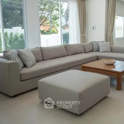 Spacious modern living room with large sofa and natural light