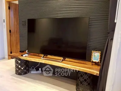 Modern living room with stylish TV setup and textured wall design.