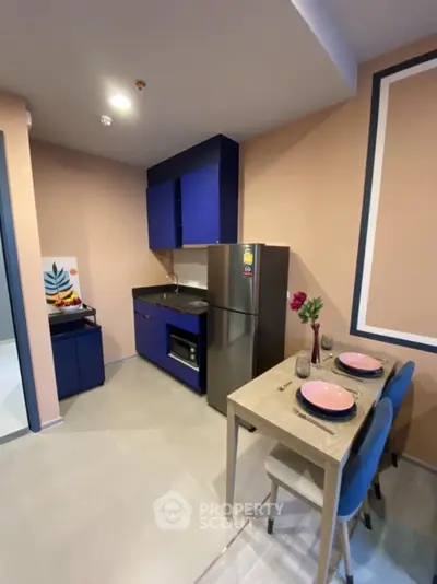 Modern kitchen with sleek blue cabinets and compact dining area