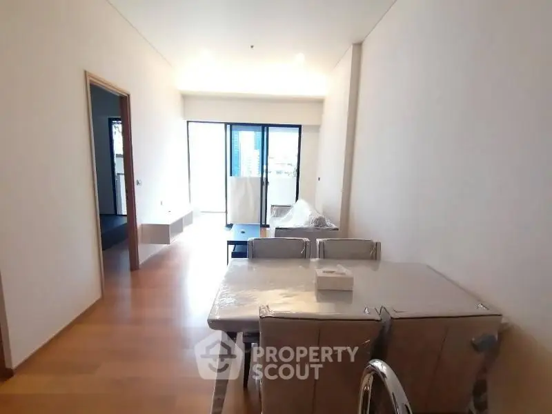 Spacious modern living room with dining area and large windows in a contemporary apartment.