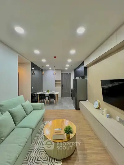 Modern living room with stylish decor and open layout, featuring a cozy sofa and sleek entertainment unit.