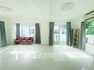 Spacious living room with large windows and garden view, perfect for family gatherings.