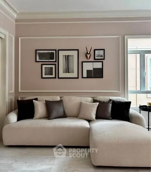 Elegant living room with modern decor and stylish wall art, featuring a plush sectional sofa and natural light.
