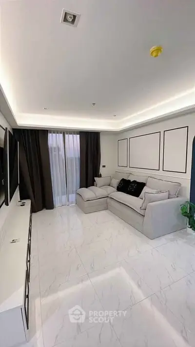 Modern living room with sleek white flooring and cozy sectional sofa, perfect for relaxation and entertainment.