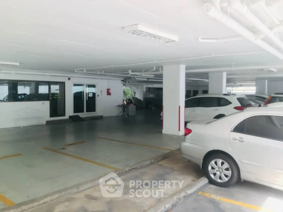 Spacious indoor parking area with multiple cars and ample lighting.