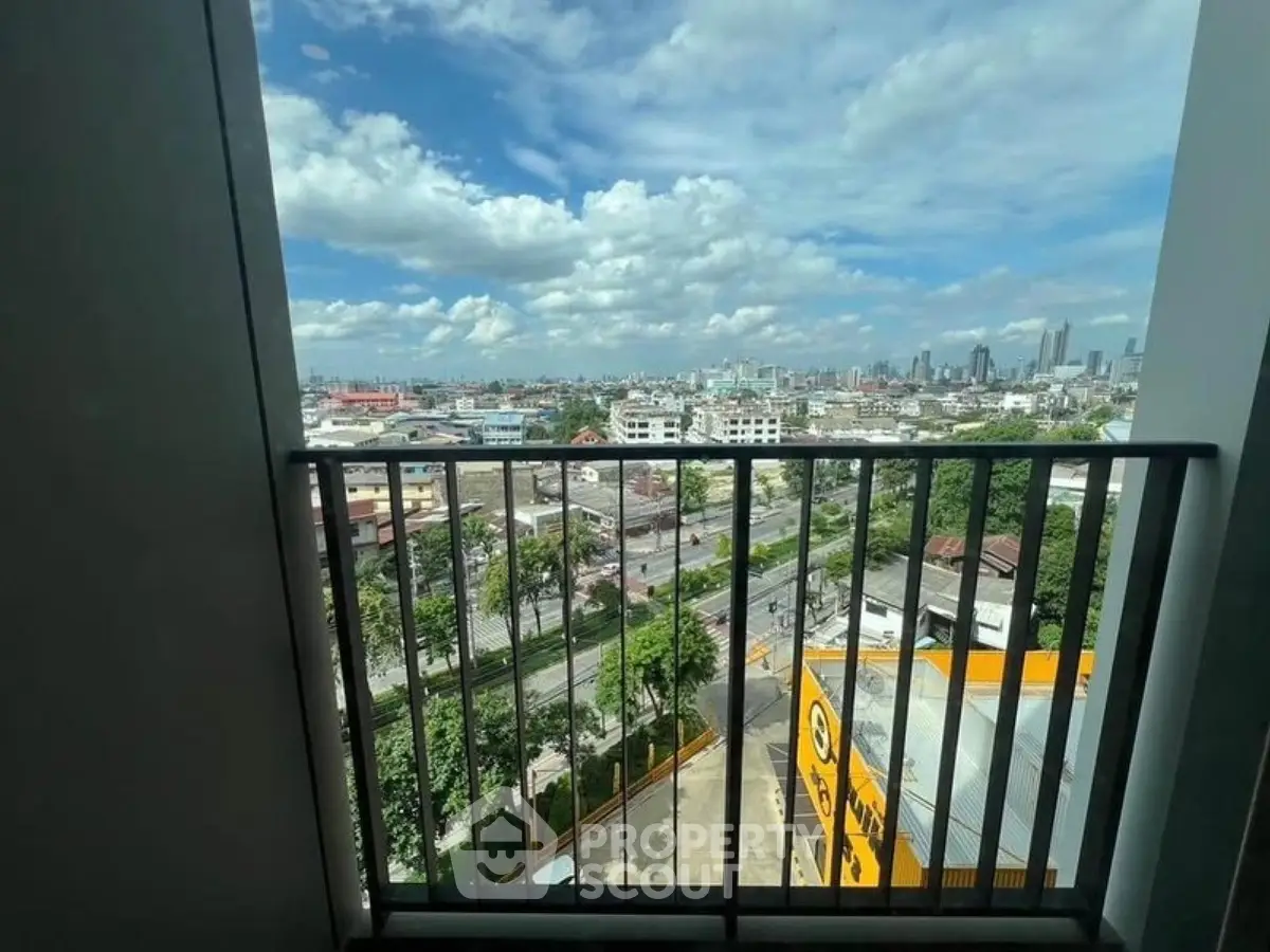 Stunning cityscape view from a high-rise balcony with clear blue skies.