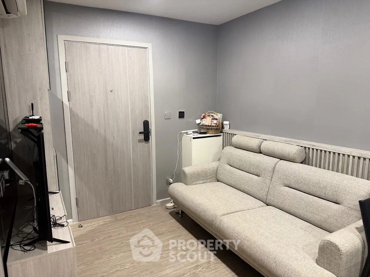 Cozy living room with modern sofa and entertainment setup, perfect for relaxation.