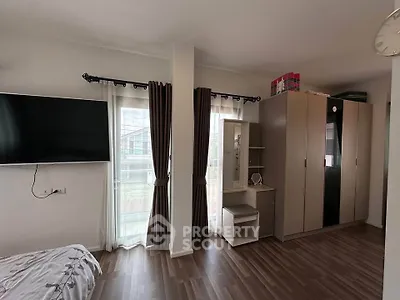 Spacious bedroom with modern wardrobe and large windows for natural light.