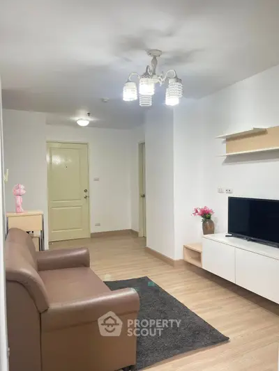 Modern living room with cozy sofa, TV unit, and elegant lighting in a stylish apartment.