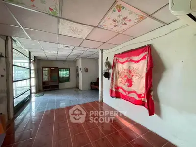 Spacious living area with tiled flooring and unique ceiling design in a cozy home.